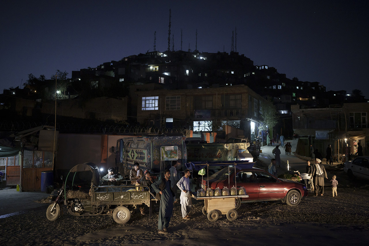 지난 16일(현지시간) 아프가니스탄 카불의 밤 거리에서 거리 상인들이 손님을 기다리고 있다. 카불=AP
