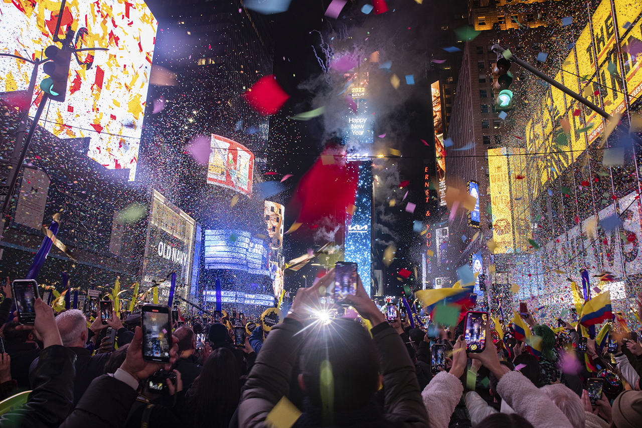 지난 1일(현지시간) 새벽 미국 뉴욕 타임스퀘어에서 새해 전야 크리스털 볼 드롭 행사에서 새해를 알리는 카운트다운 후 형형색색의 색종이가 빌딩 숲을 물들이자 시민들이 사진을 찍고 있다. 뉴욕=AP
