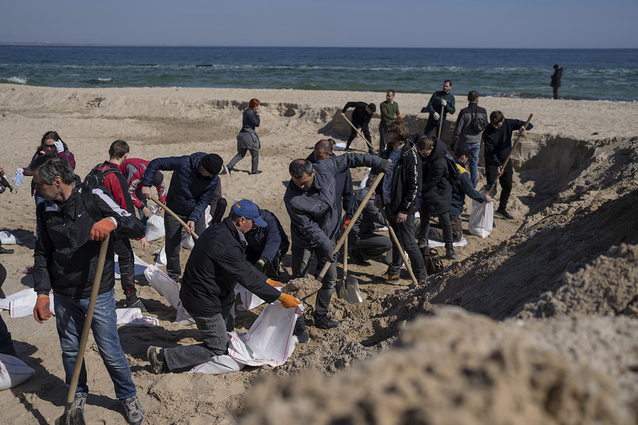 23일(현지시간) 우크라이나 남부 오데사의 해변에서 자원봉사자들이 도시를 방어하기 위해 모래주머니를 만들고 있다. 오데사=AP