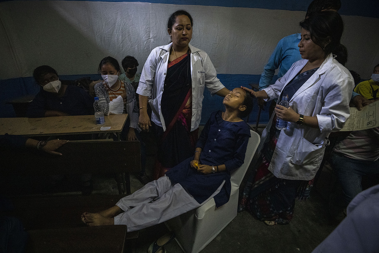 지난 3월 16일(현지시간) 인도 가우하티의 한 학교에서 의료진이 코로나19 코르베백스 백신을 접종한 후 현기증을 느낀 한 소녀를 살피고 있다. 사진=AP
