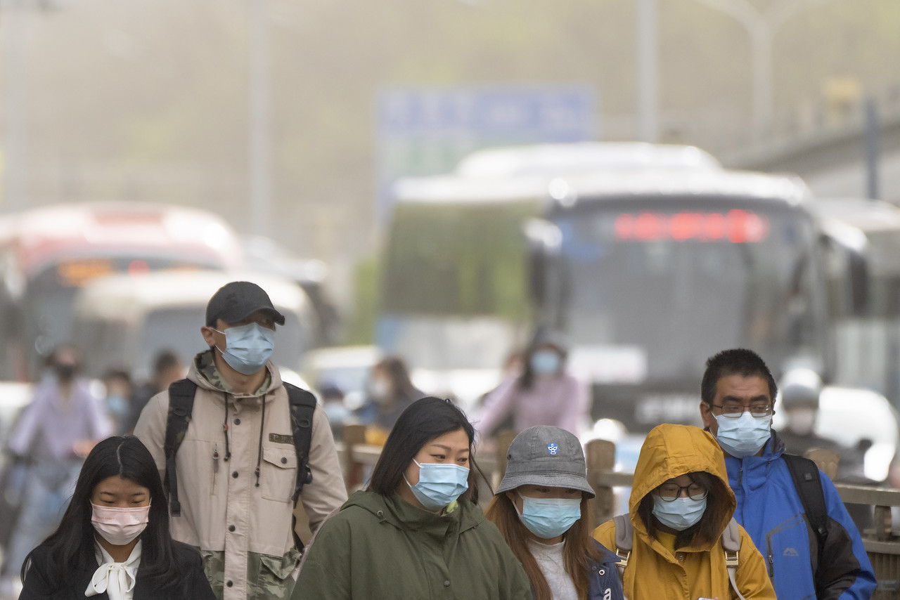 지난 11일 중국 베이징에서 출근길 시민들이 마스크를 쓴 채 황사에 뒤덮인 시내를 지나고 있다. 전날 밤부터 베이징을 덮친 황사와 모래폭풍으로 강풍 경보와 황사 경보가 동시에 발령됐다. 베이징=AP
