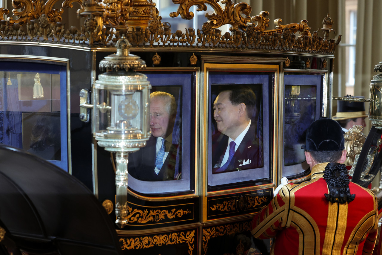 영국을 국빈 방문 중인 윤석열 대통령이 21일(현지시간) 찰스 3세 국왕과 함께 마차를 타고 런던 버킹엄궁으로 들어서고 있다. 공동취재사진